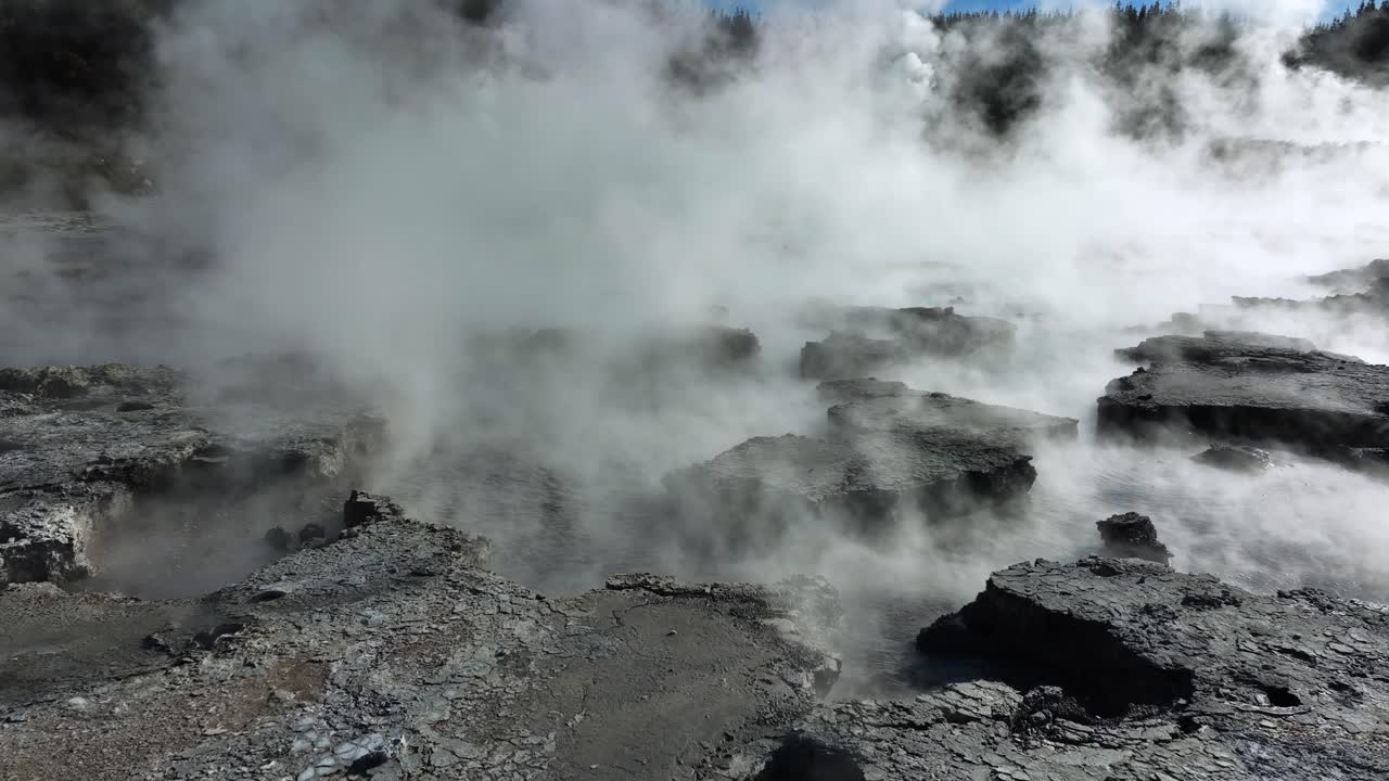 steam bubbling out of mud pools, Drone slowly flying over geothermal landscape. Trees, steam, bubbling mud and steam. Alien Landscape. Sci-fi. Global Warming