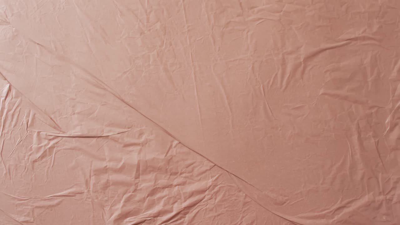 Video in primo piano di tessuto beige stropicciato con spazio per il testo