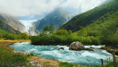 briksdal glacier with a mountain river in the foreground