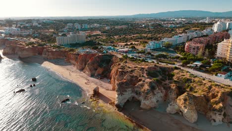 aerial view of cliffs and beach in portugal's algarve at sunset