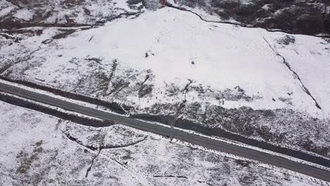 AERIALS-of-Snowy-landscape-in-Lesotho,-Africa---Snow-fall-in-Africa-Car-driving-on-roads-in-snowy-landscape