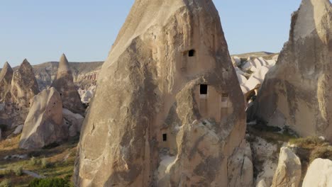 volando hacia las ventanas talladas en formaciones rocosas de chimeneas de hadas vista aérea de capadocia turquía