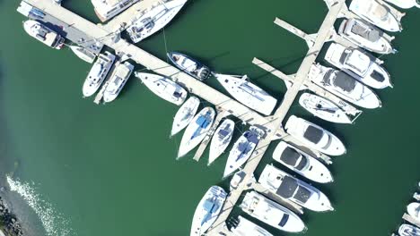 girando sobre el puerto deportivo en un barrido panorámico lento que revela la pasarela y los muelles en los que están estacionados los barcos