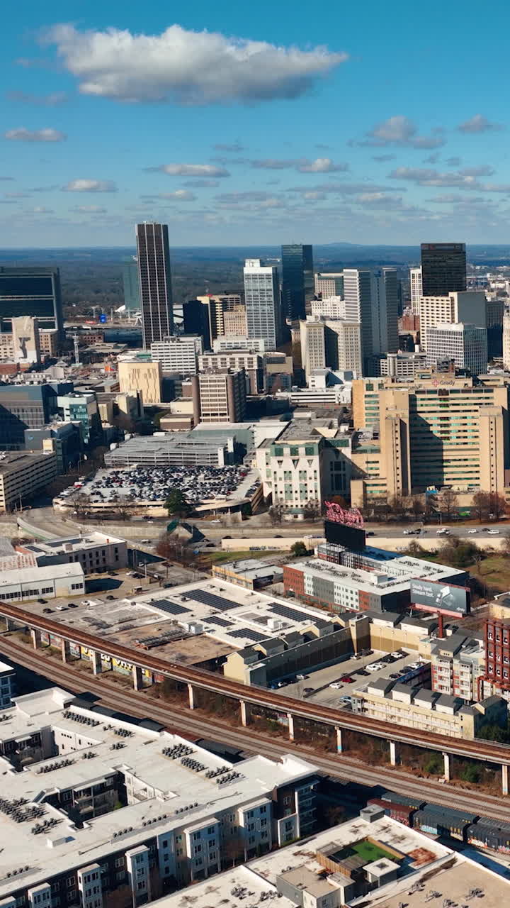 Atlanta, Georgia, USA - January 02, 2024: Aerial view of the central part of the city with streets, houses, cars, parking lots and subway line. Vertical video
