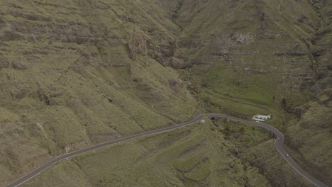 toma panorámica de un camión conduciendo a través de una carretera con curvas en un cañón con montañas
