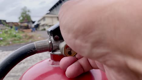 the hand is removing the seal of locking pin on the handle of the fire extinguisher