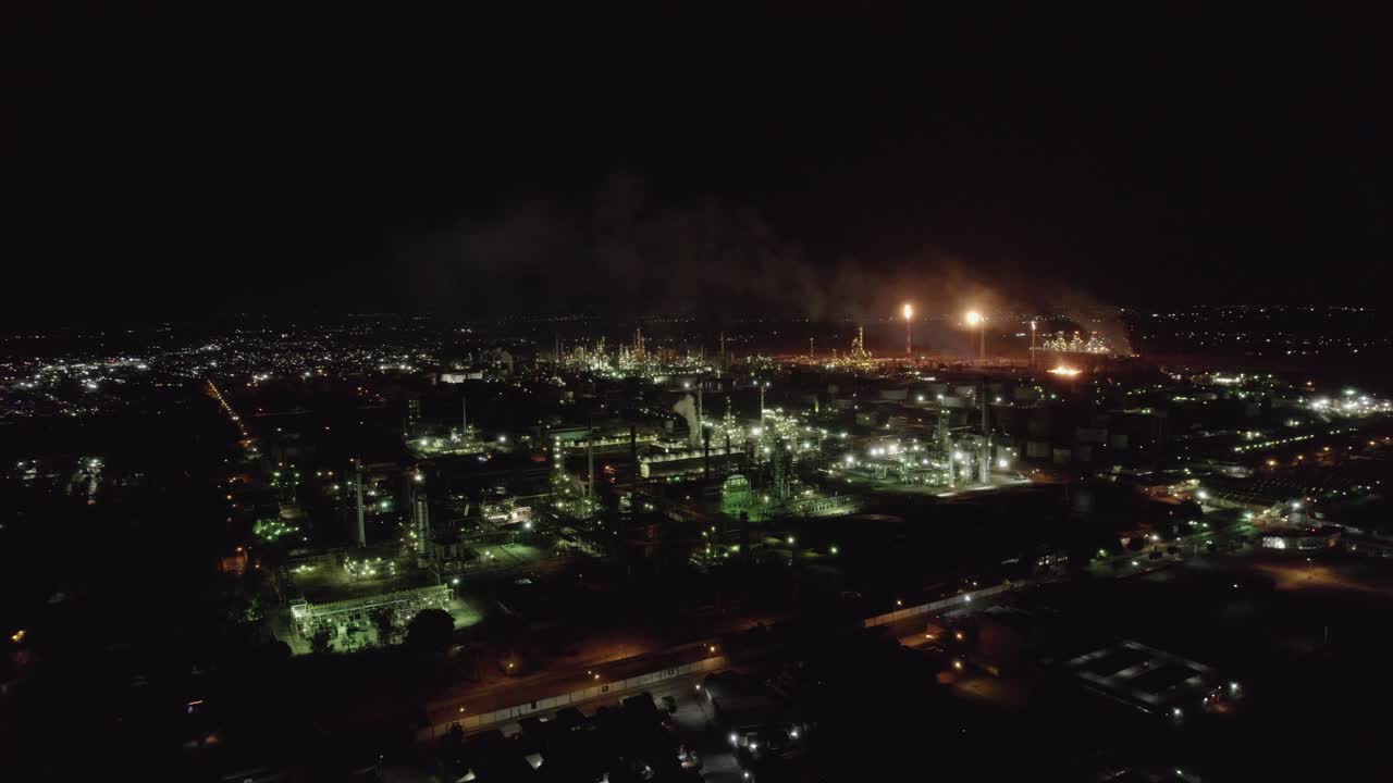 toma aérea de una refinería en una noche contaminada