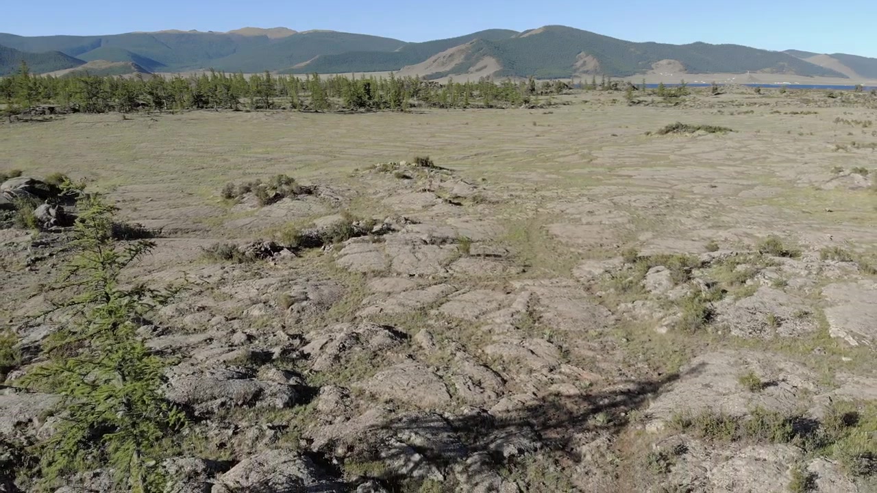 Vista aerea di un campo di lava vulcanica con montagne in lontananza