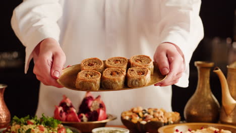 a chef presenting a plate of baklava