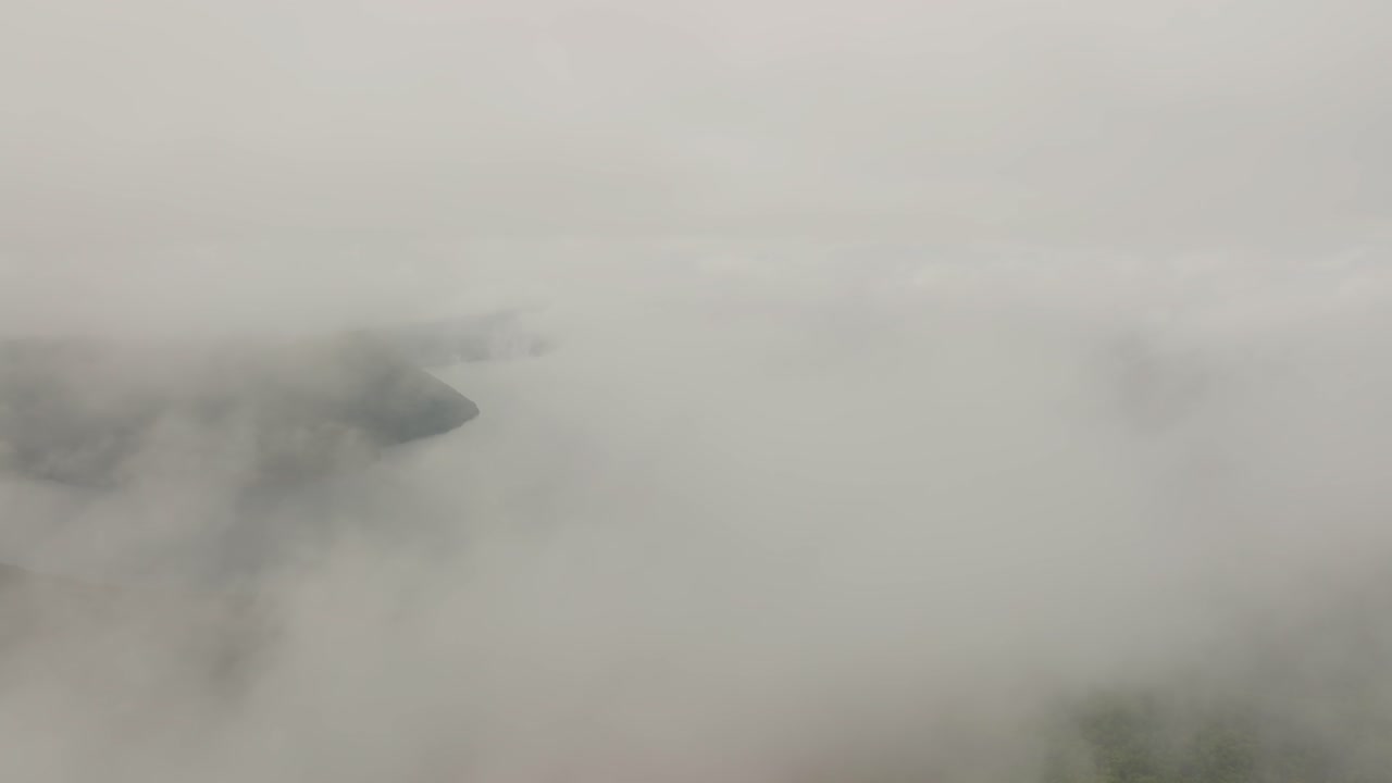 Aerial drone fly above white clouds revealing Lake Mashu's volcanic waters landscape in Hokkaido Japan