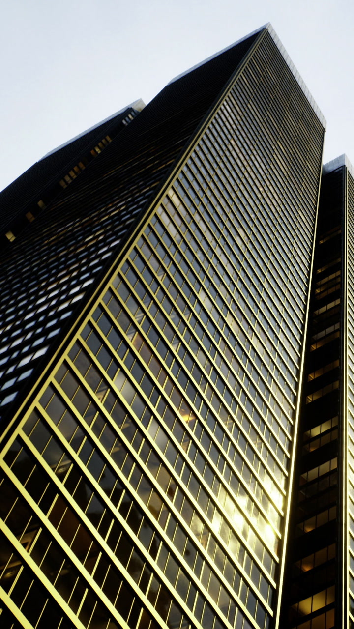 Tall building with glass windows reflecting light in urban setting