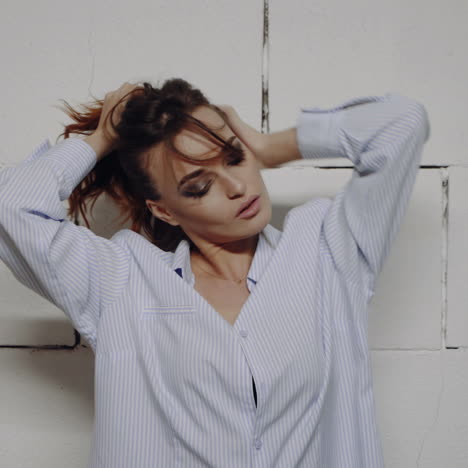 woman in a striped shirt posing in front of a brick wall