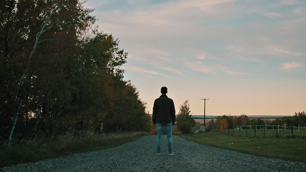 Man Standing on Road at Dusk