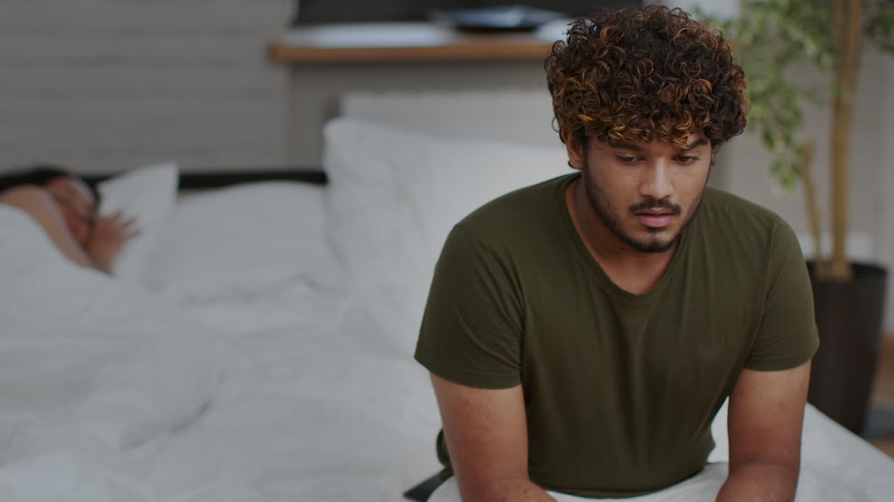 Homem chateado enquanto o parceiro dorme