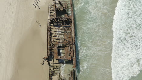 Top-view-drone-shot-of-the-old-shipwreck,-SS-Maheno,-on-a-beach-of-Fraser-Island,-Australia