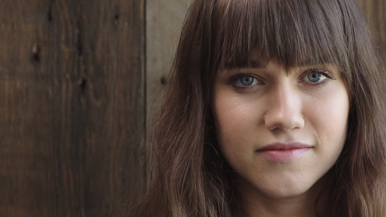 retrato de una hermosa mujer joven mirando a la cámara sonriendo linda mujer joven caucásica con ojos azules en un fondo de madera copyspace
