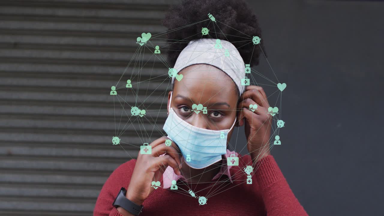 Adult woman grabbing mask, securing mask, green health icons hovering over head signaling safety