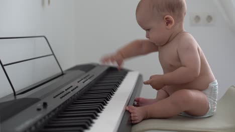 toddler baby boy, playing piano at home, child learning
