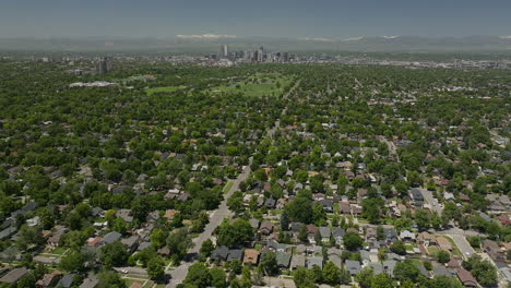 Downtown-Denver-homes-City-Park-museum-Golf-Course-cityscape-Rocky-Mountain-landscape-14ers-Mount-Evans-aerial-drone-cinematic-foothills-Colorado-spring-summer-green-lush-forward-pan-up-movement