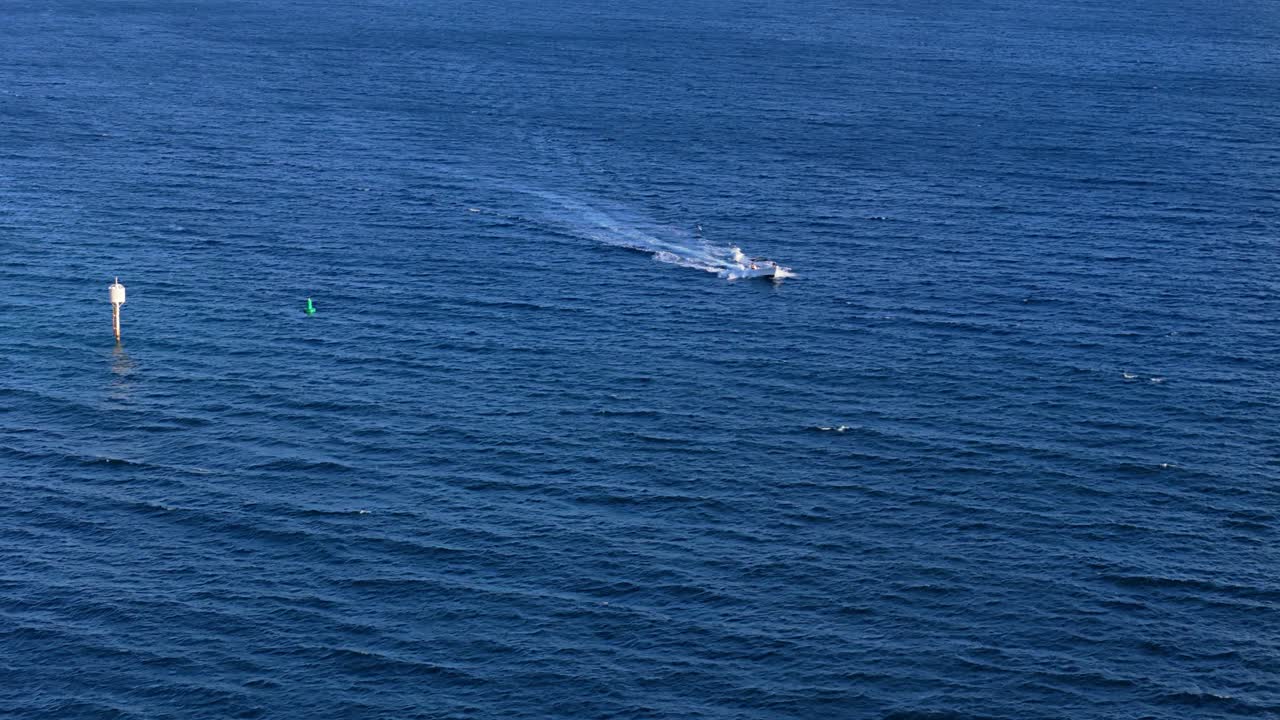 시 보트가 깊은 파란 바다 물을 가로질러 보이를 통과합니다.