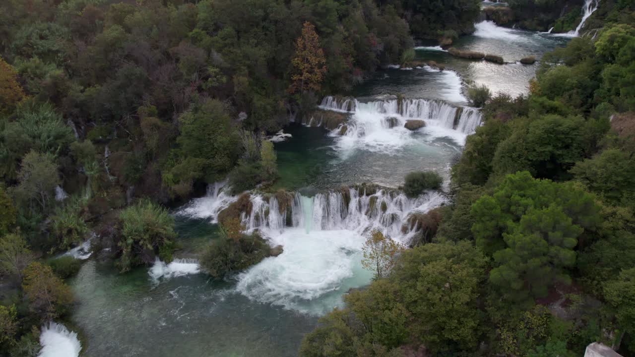 Cascata di Krka e fiume sereno circondati da foresta, vista aerea, Croazia