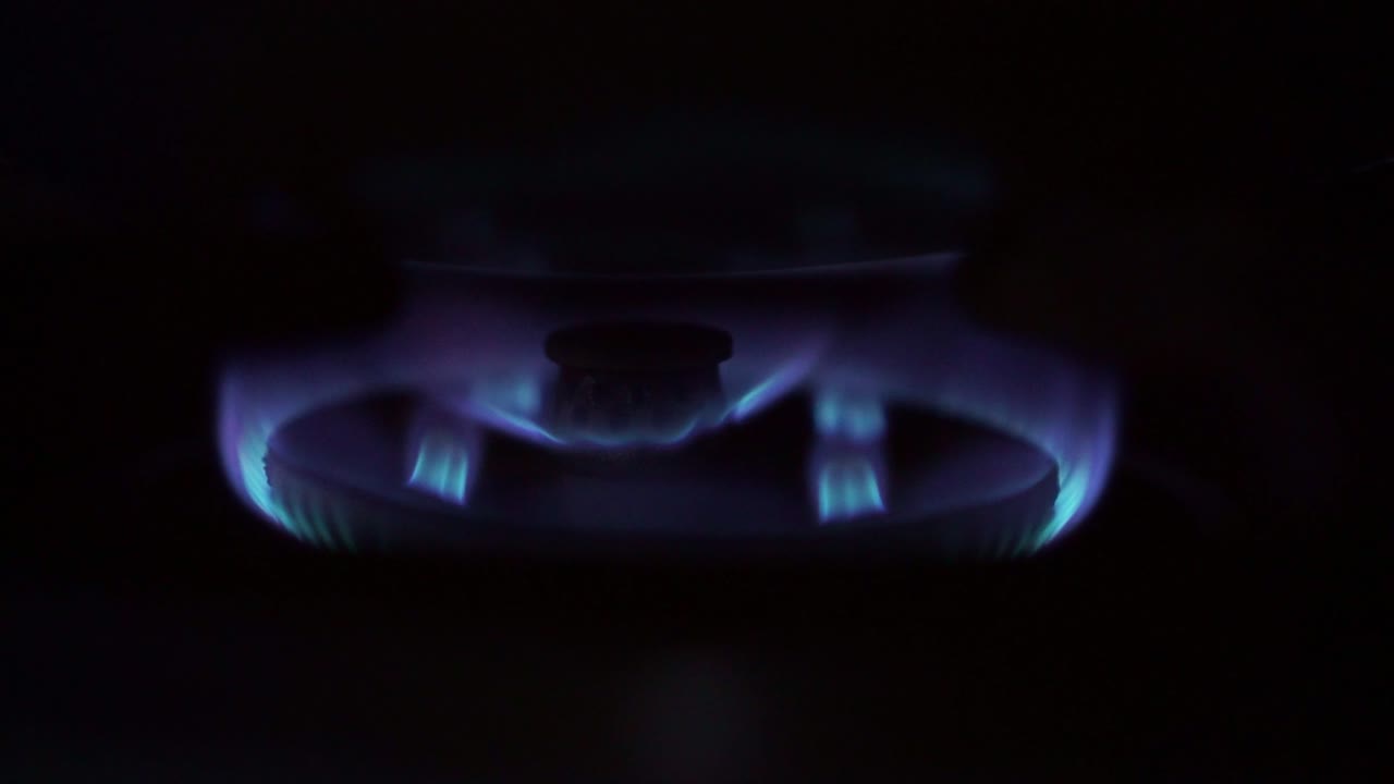 Đầu đốt bếp gas với ngọn lửa xanh sáng, nguồn nhiệt nhà bếp để chuẩn bị bữa ăn