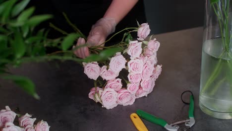 florista arreglando un ramo de rosas rosas