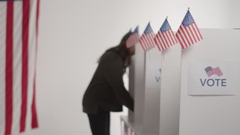 voters in booths with ballot papers casting votes in american election