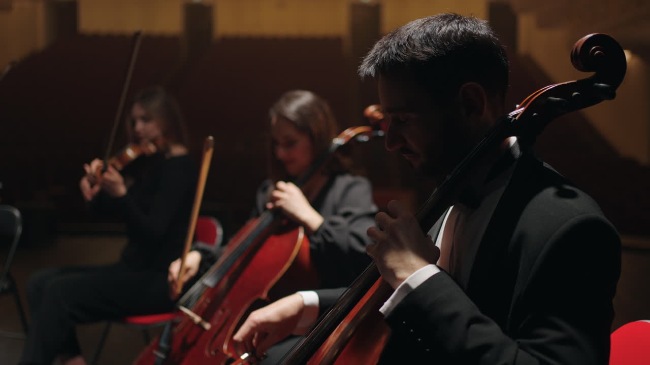 ensayo de la orquesta sinfónica en la casa de la ópera los violonchelistas están tocando en la escena de la sala filarmónica