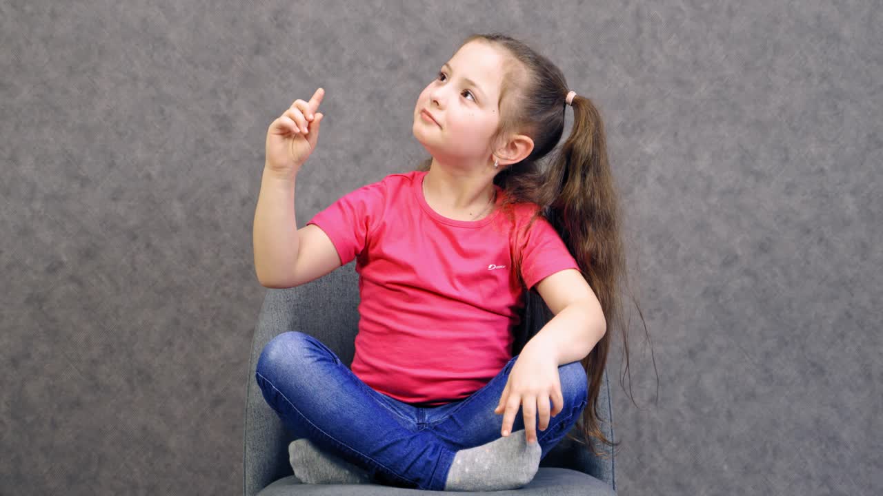 Portrait of exited and happy girl. Girl pointing finger up with successful idea