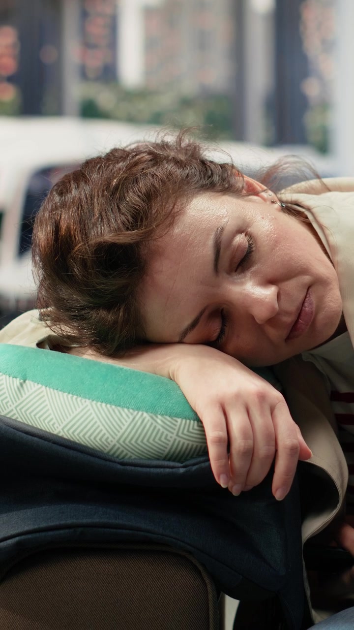 Tired Woman Sleeping on Luggage at Airport Terminal
