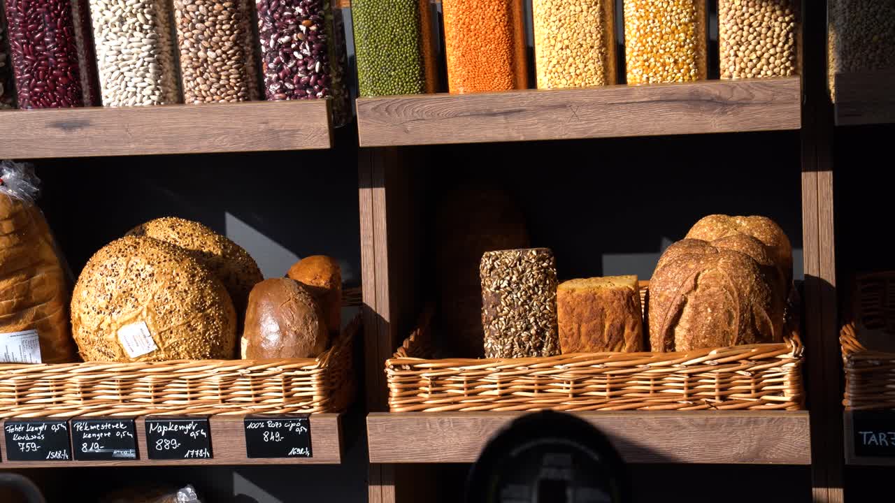 Assortment of fresh artisanal bread loaves and dry legumes displayed in wicker baskets