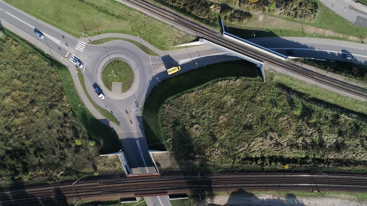 출발과 함께 와이드 샷으로 드론에서 기록된 화창한 날에 지나가는 자동차가 있는 포장된 거리의 원형