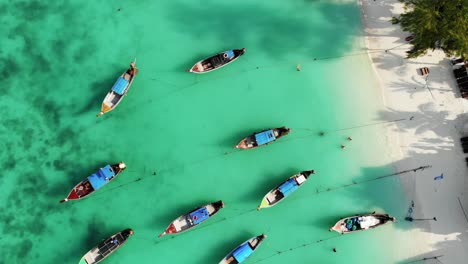 top down view of long tail boats in tropical blue sea in thailand