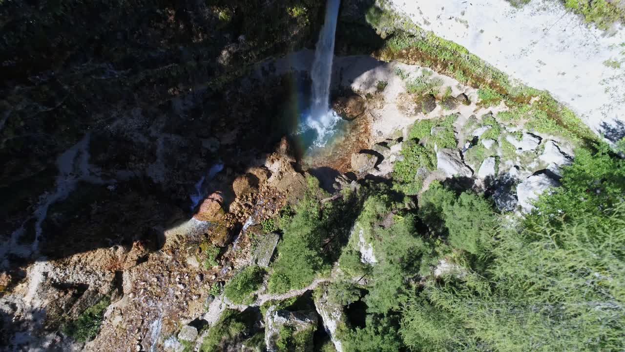 Vista aerea discendente di una cascata isolata che forma un piccolo ruscello in mezzo a una fitta e densa foresta