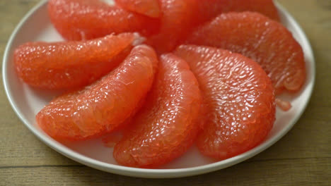 fresh red pomelo fruit or grapefruit on plate