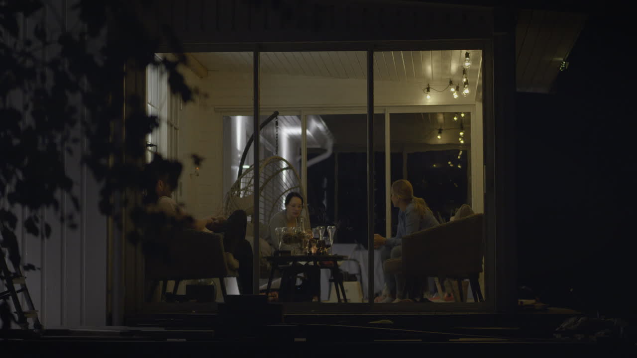 친구 들 은 가을 밤 에 럭셔리 한 야외 유리 닫힌 마당 을 즐기고 있다