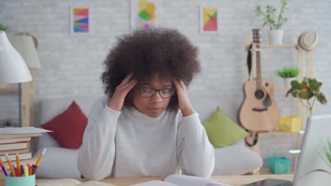 tired and exhausted african american students woman with an afro hairstyle at home