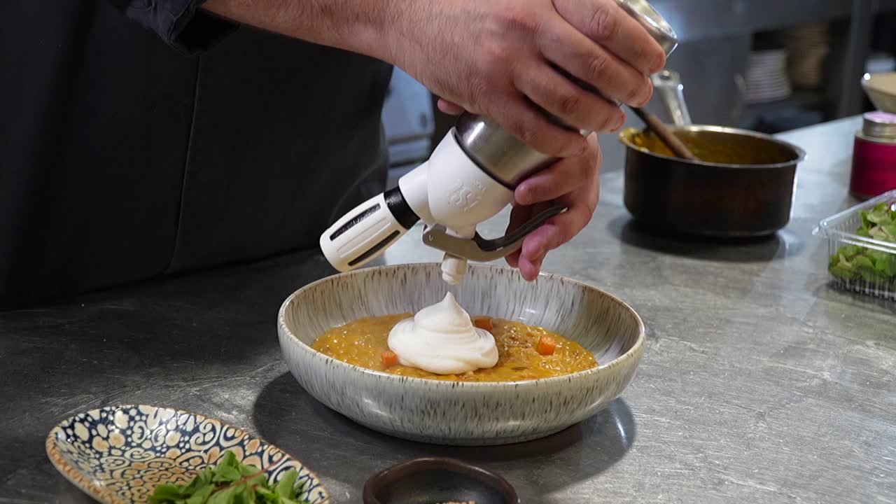 Chef’s Final Touches: Siphon Whipped Cream in Soup Closeup