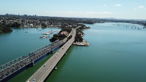 Antena:-Dron-Volando-Junto-A-Un-Puente-Con-Tráfico-Circulando-A-Través-De-él-En-Sydney,-Nsw