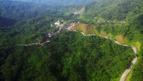 aerial view of road in the mountain with lush green forest in summer