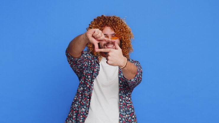 Man photographer gesturing picture frame with hands looks through fingers focusing cropping image