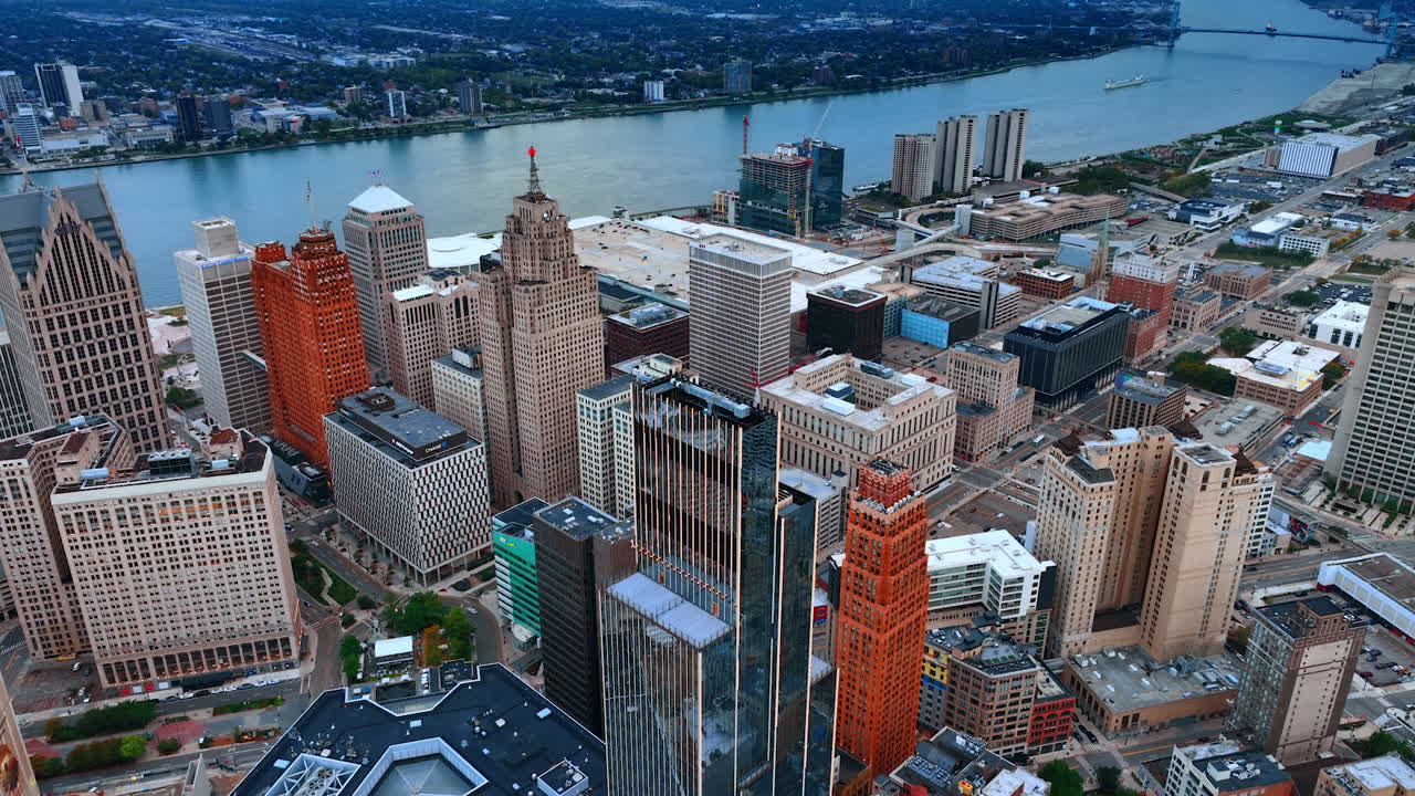 Detroit, USA, 28 July 2025: Downtown of Detroit, Michigan, USA at the waterfront of the Detroit River. A long boat approaches by the waterscape. Aerial view