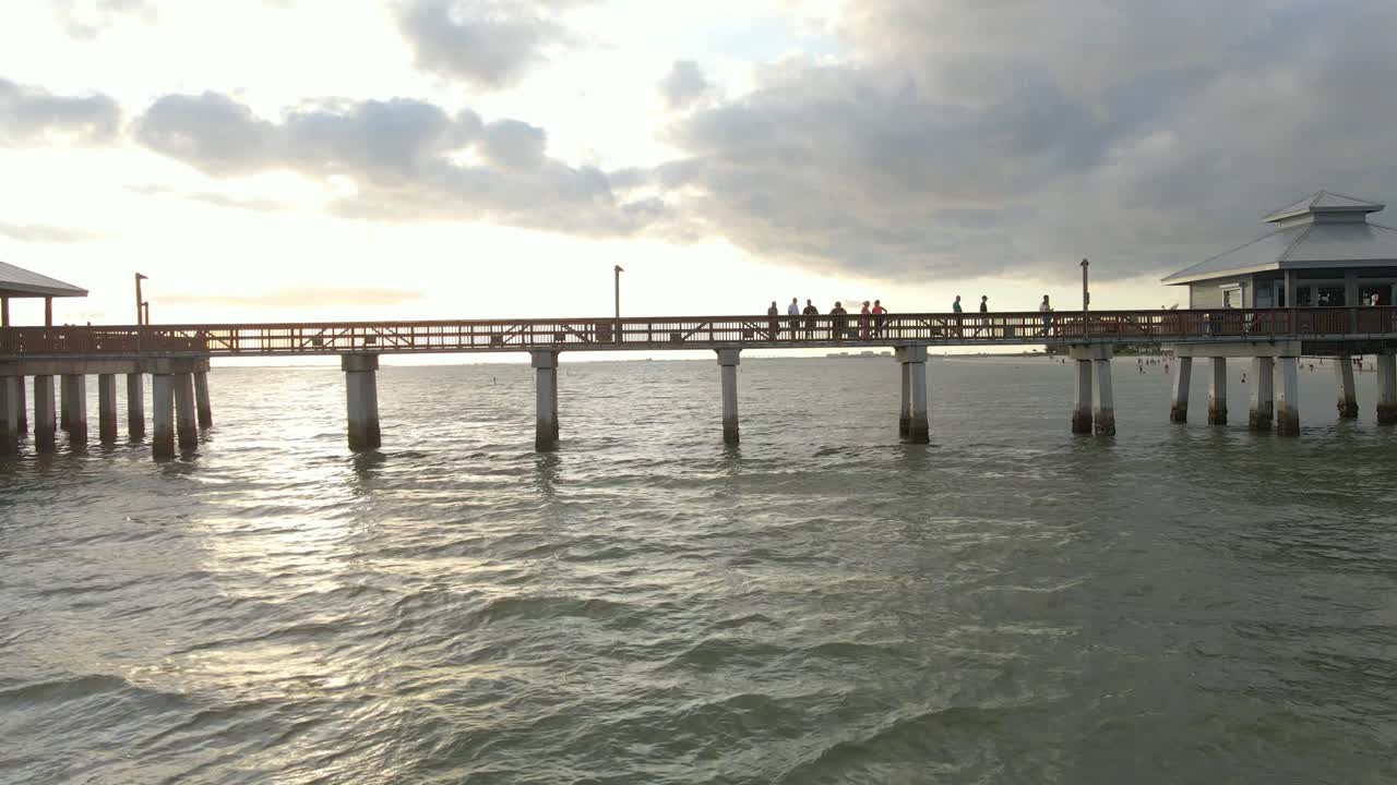 Aerial view people walking at Fort Myers iconic Pier during sunset, Florida