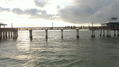 Vista-Aérea-De-Personas-Caminando-En-El-Icónico-Muelle-De-Fort-Myers-Durante-La-Puesta-De-Sol,-Florida