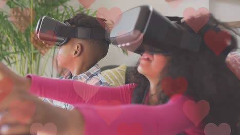 animation of hearts over african american siblings using vr headsets