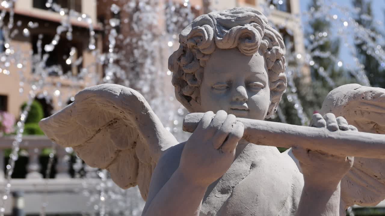 estatua de ángel tocando la flauta cerca de la fuente de agua
