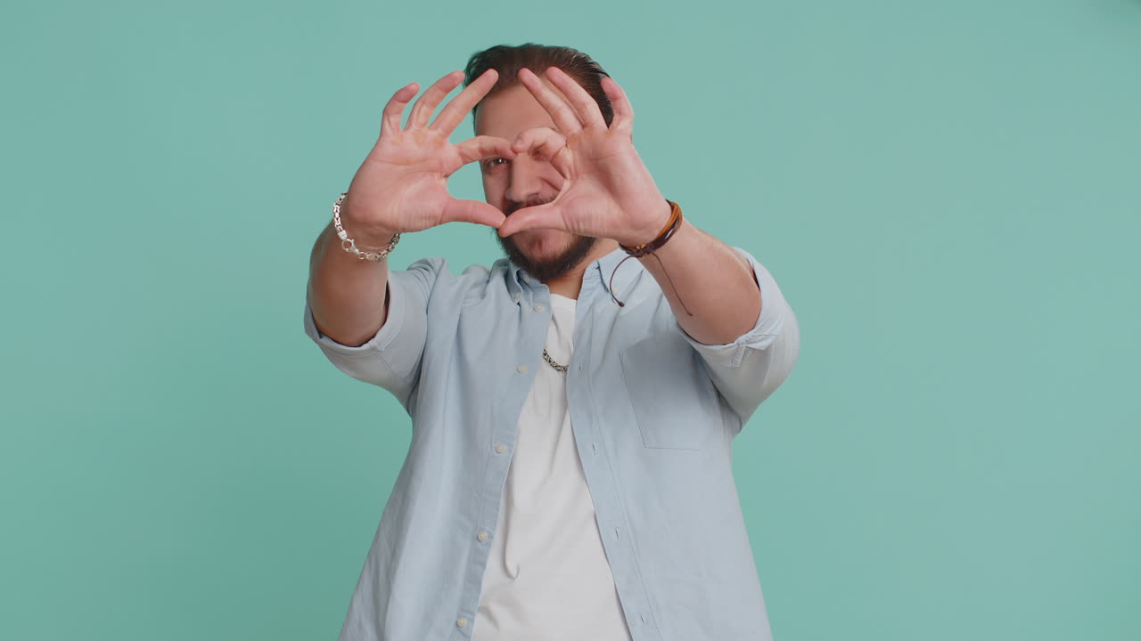 el hombre árabe sonriente hace un gesto del corazón demuestra el amor señal expresa buenos sentimientos y simpatía