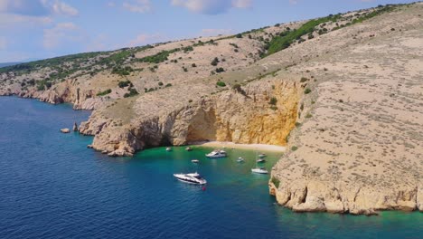 Costa-Acantilada-De-La-Isla-Croata-Krk-Con-Playa-De-Arena-Aislada-Bahía-Dorada-Y-Yates-De-Lujo-Flotando-En-La-Tranquila-Laguna