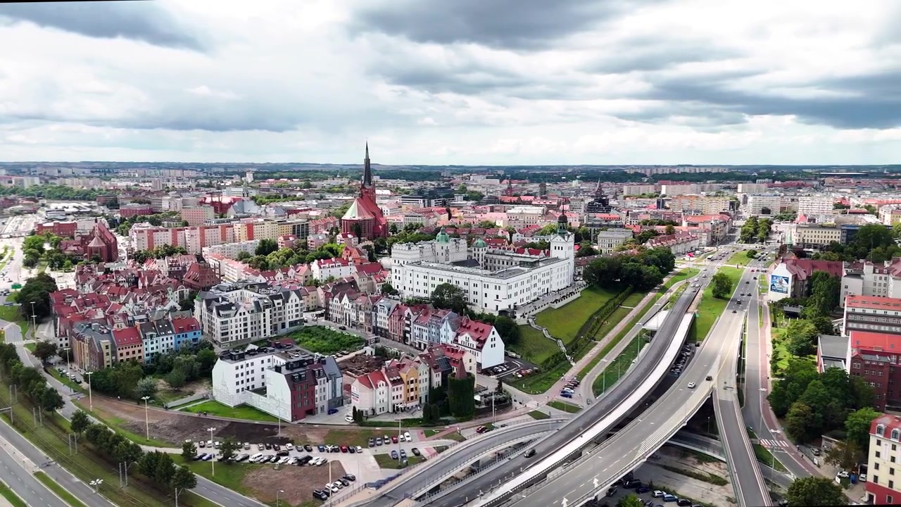 Uma ampla vista aérea panorâmica mostrando o histórico Castelo dos Duques da Pomerânia, a Basílica Catedral de São Tiago e a paisagem urbana de Estetino, Polônia.